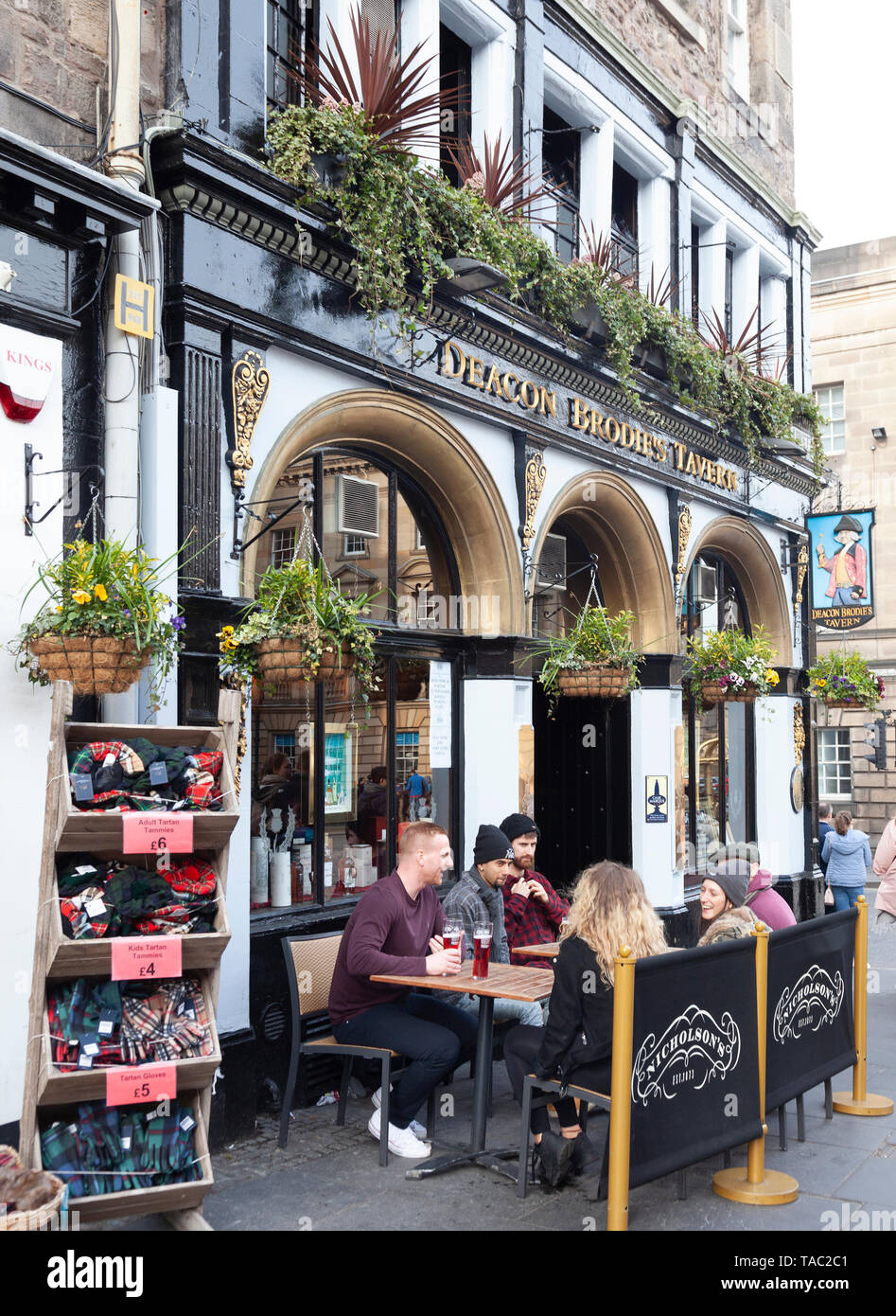 Customers relaxing in the outdoor seating area outside Deacon Brodie's Tavern in Lawnmarket, in the Old Town area of Edinburgh, Scotland, UK. Display  Stock Photo