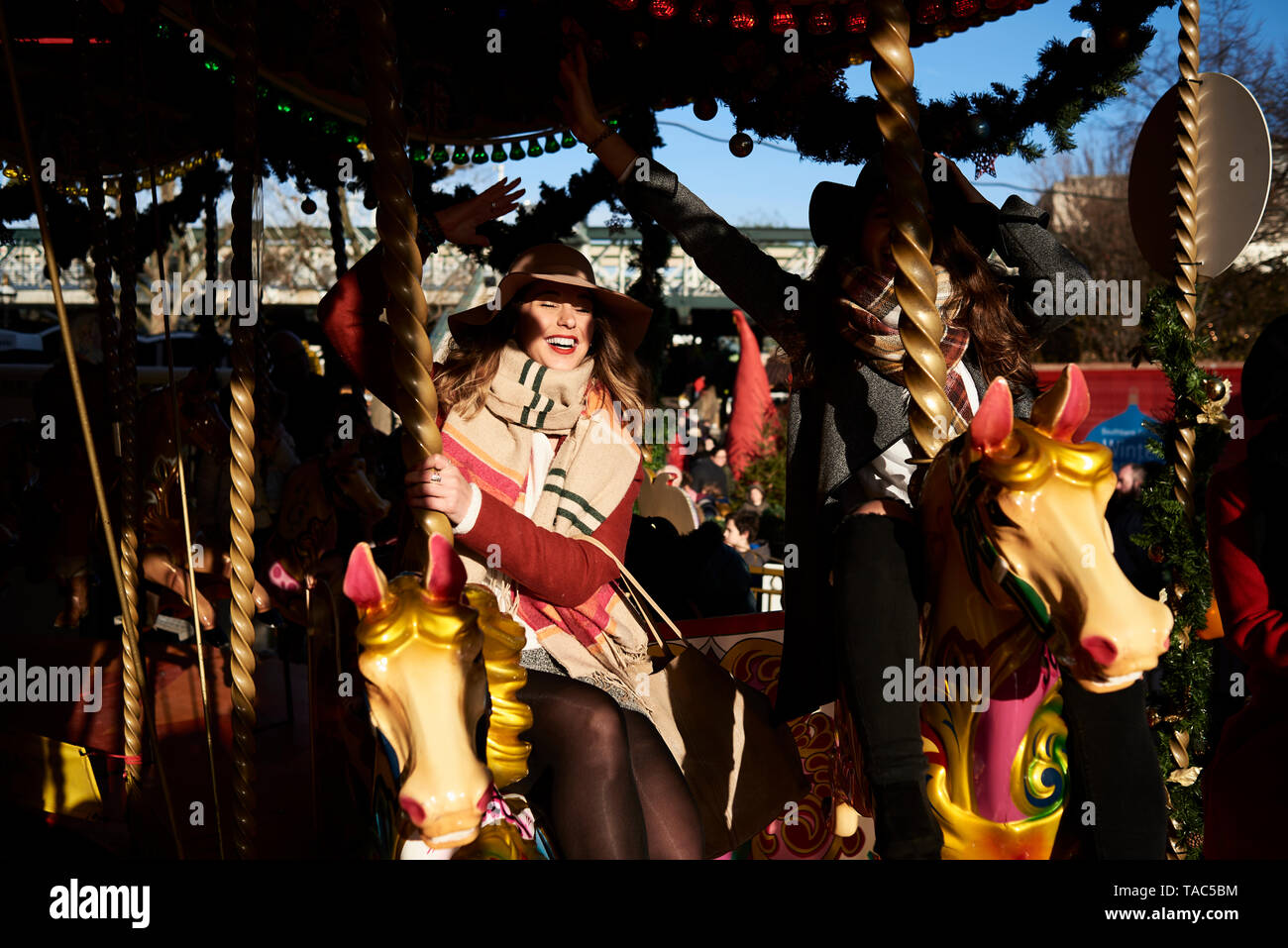 Two happy women having fun on a carousel Stock Photo