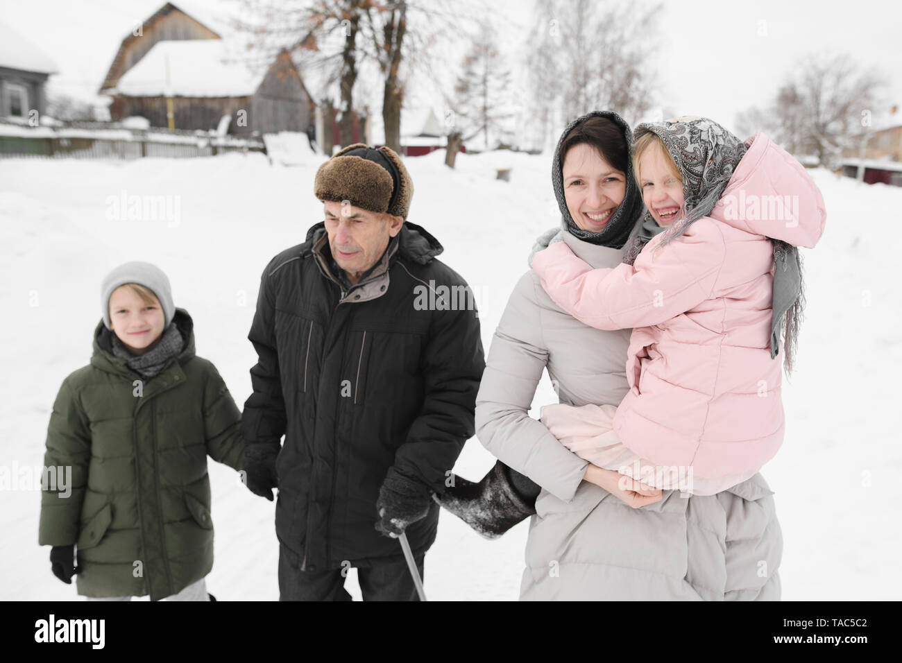 Grandfather strolling together with daughter and grandchildren in winter Stock Photo