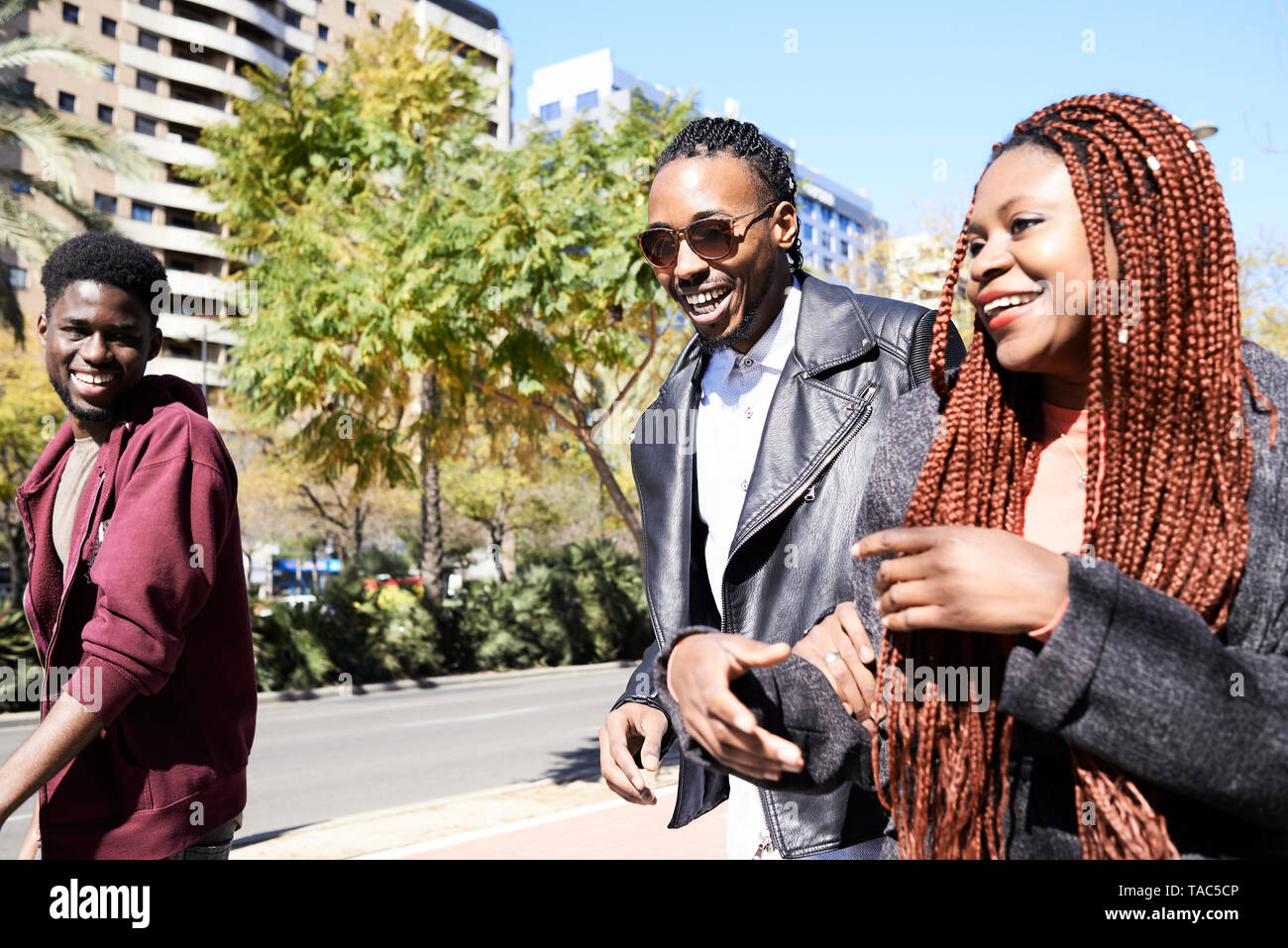 Three happy friends on the go in the city Stock Photo