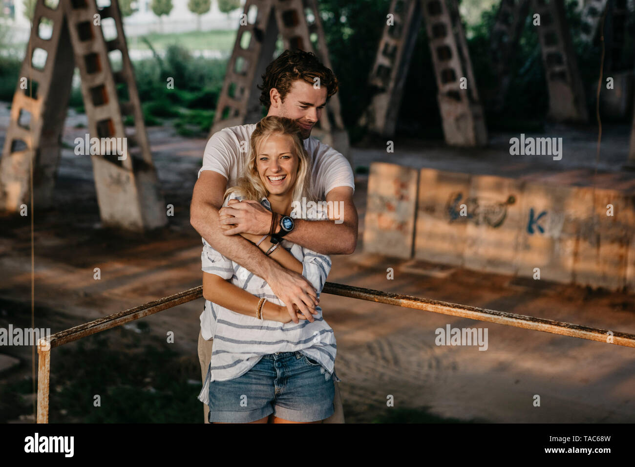 Portrait of happy young couple in an old train station Stock Photo