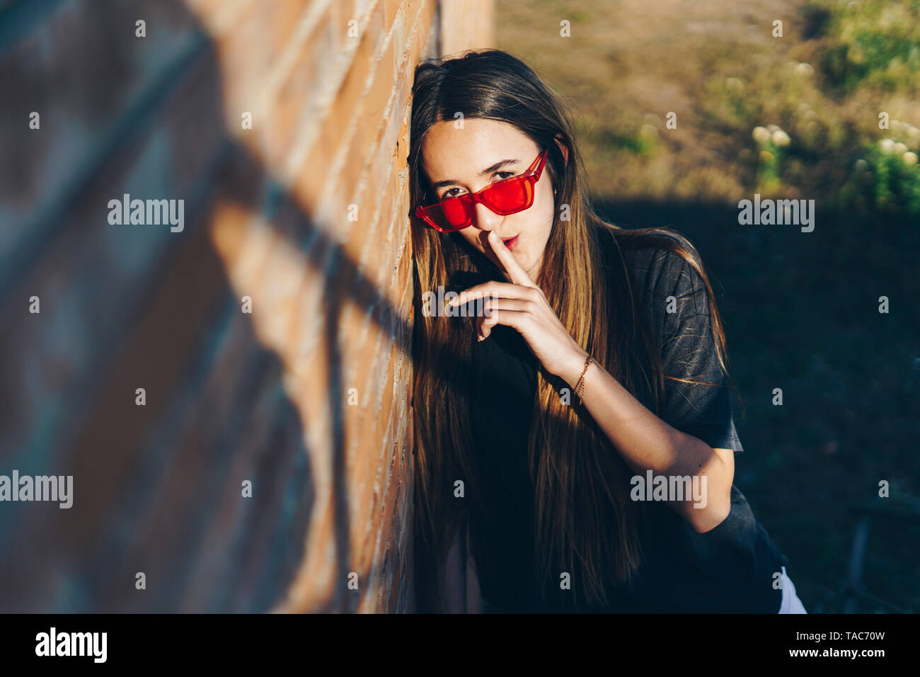 Spain, portrait of a teenage girl with finger on mouth Stock Photo