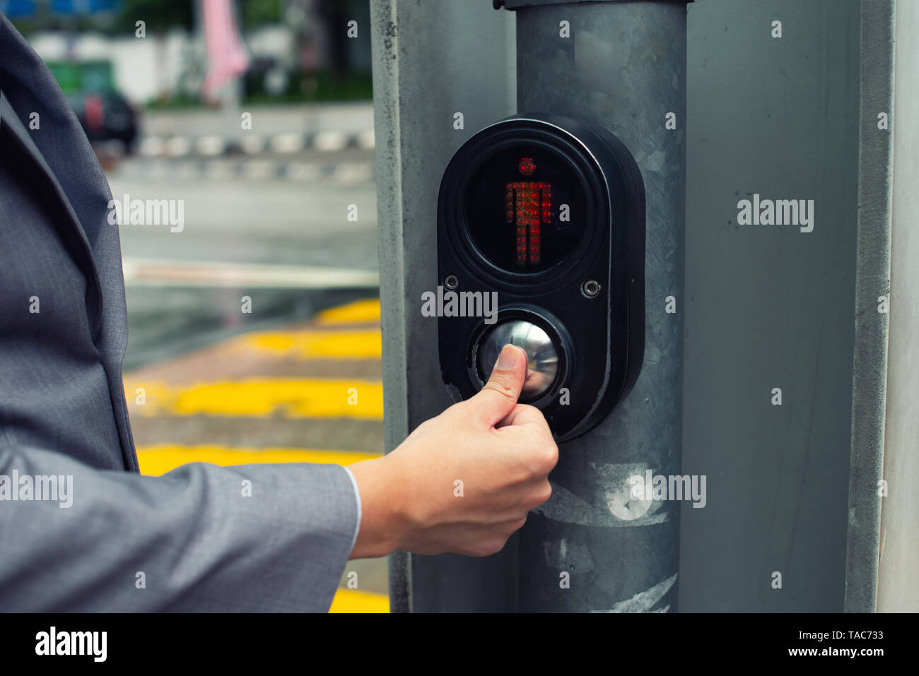 businessman hand pressing pedestrian crossing light button Stock Photo