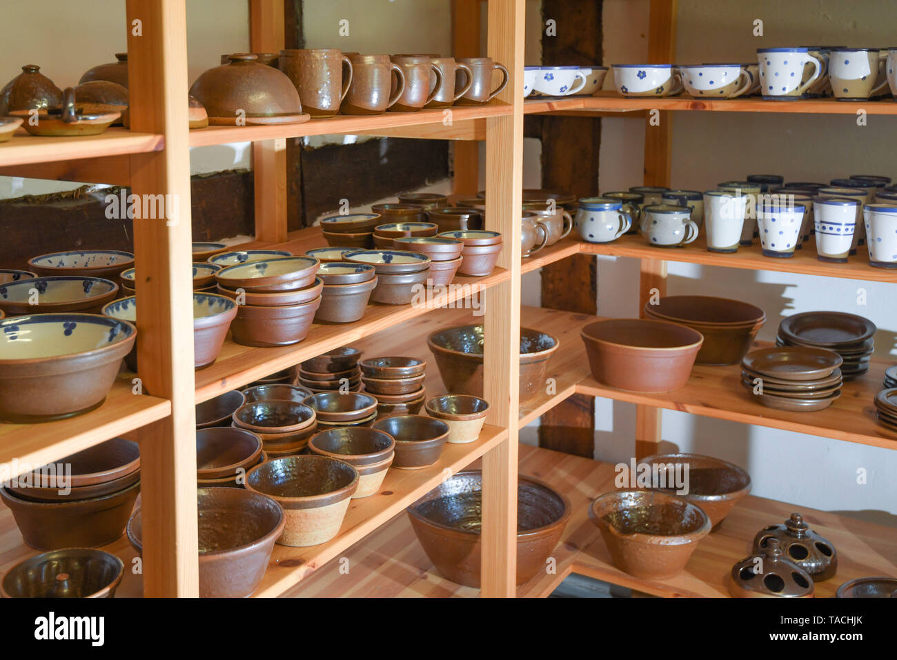 24 May 2019, Brandenburg, Groß Neuendorf: Jugs, cups and other vessels are on the shelves of the potter Manfred Dannegger. Since 1997 the potter has been producing this clay glazed stoneware in the tradition of Bunzlau brownware. The dishes are fired in the oven at about 1300 degrees Celsius for about 20 hours. The oven must then cool for four days. This weekend (25.05./26.05.) the 12th pottery market will take place in Groß Neuendorf. Then 22 potters from near and far present themselves directly at the dike of the German-Polish border river Oder. Photo: Patrick Pleul/dpa-Zentralbild/ZB Stock Photo