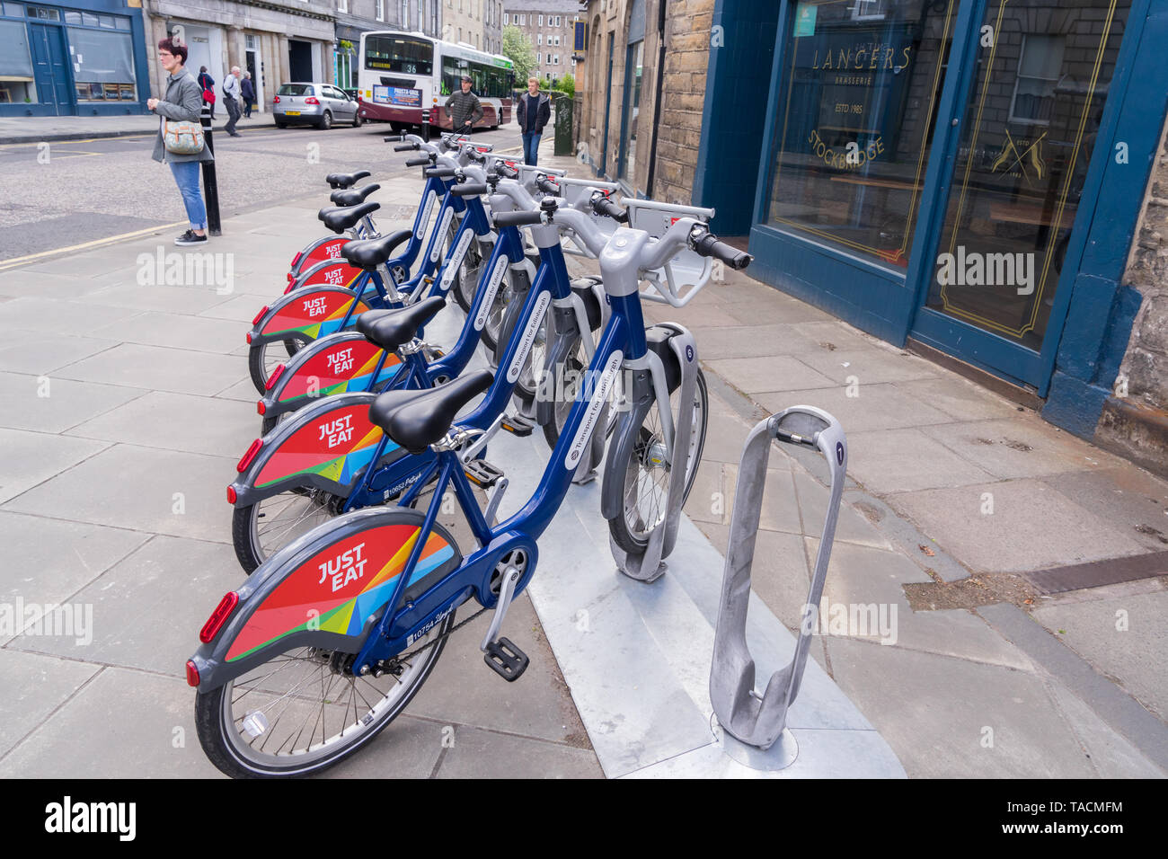 Cycles For Hire at a docking station in Stockbridge, Edinburgh. Sponsored by Just Eat Stock Photo