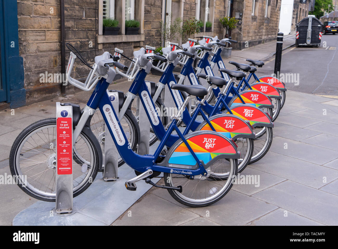 Cycles For Hire at a docking station in Stockbridge, Edinburgh. Sponsored by Just Eat Stock Photo