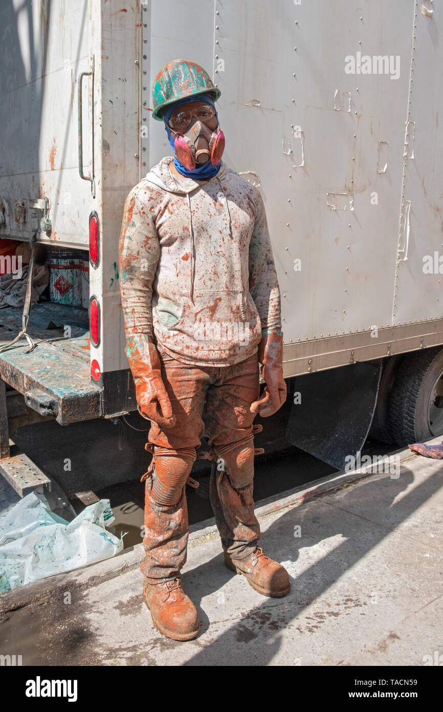 Posed portrait of a construction worker covered in paint on a subway ...