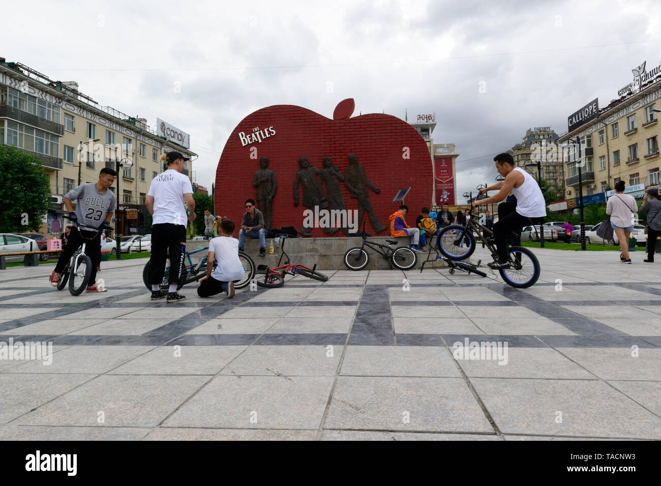 Beatles Square, Ulaanbaatar, Mongolia. Youngsters playing with their BMX bicycles in front of the Fab Four. Stock Photo