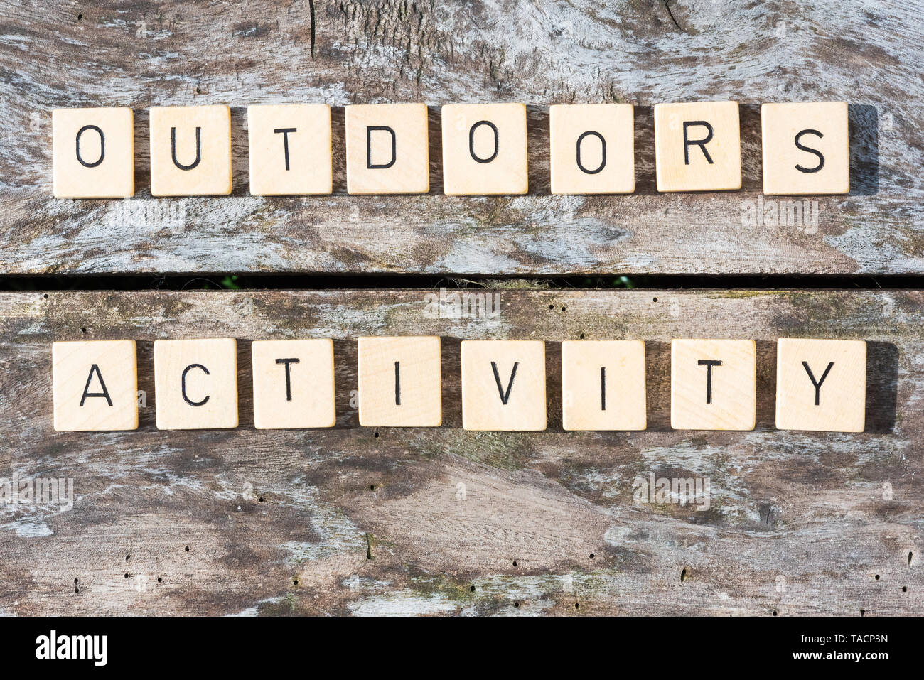 Outdoors activity words on a wood table in sunlight top view Stock