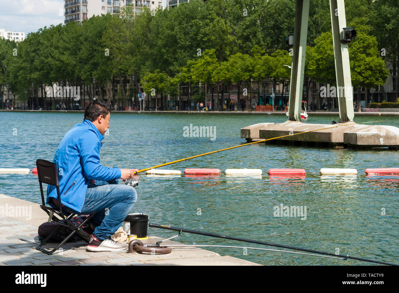 Man fishing in the Bassin de la Villette, Paris, France Stock Photo