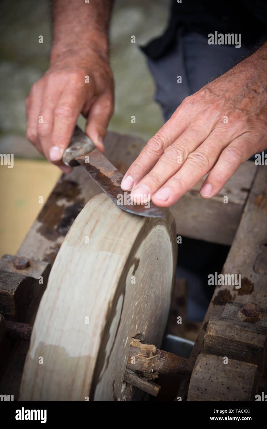 https://c8.alamy.com/comp/TACXXH/sharpening-knife-on-old-grindstone-wheel-TACXXH.jpg