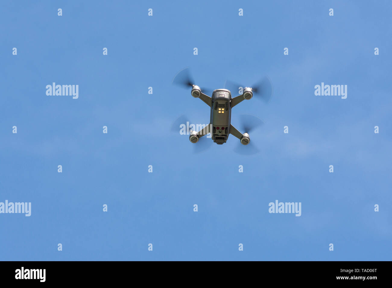 Drone copter, DJI Spark, flying with high resolution digital camera, hovering in sky. Stock Photo