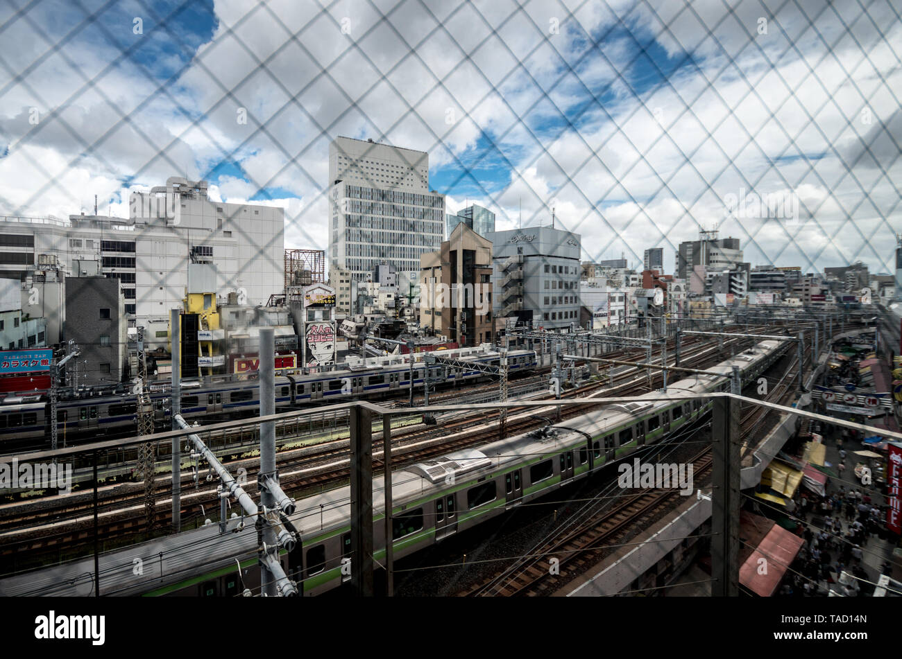 Train tracks crossing the city. View from the iron net. Stock Photo