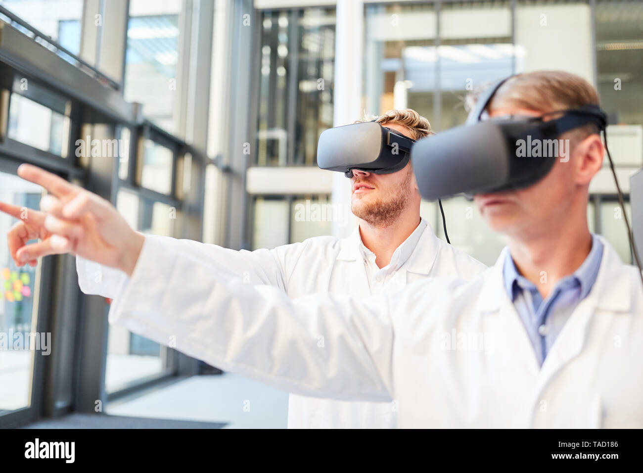 Two researchers train with VR glasses in simulation for medical applications Stock Photo