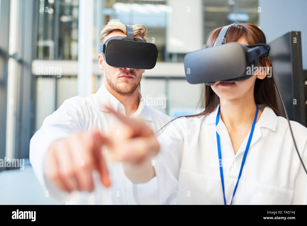 Two researchers train 3D simulation for medicine application with virtual reality glasses Stock Photo