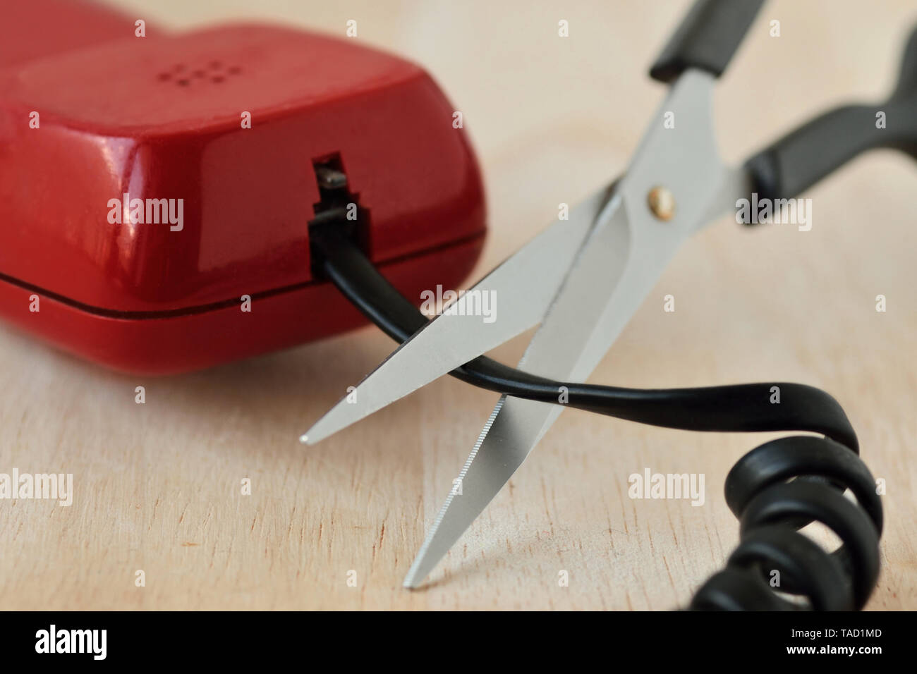 Scissors cutting telephone cord - Concept of landline phone Stock Photo