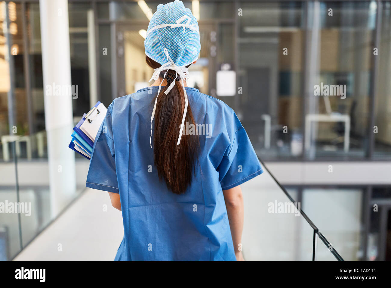 Surgeon in blue surgical gown with patient files in front of the clinic emergency room Stock Photo