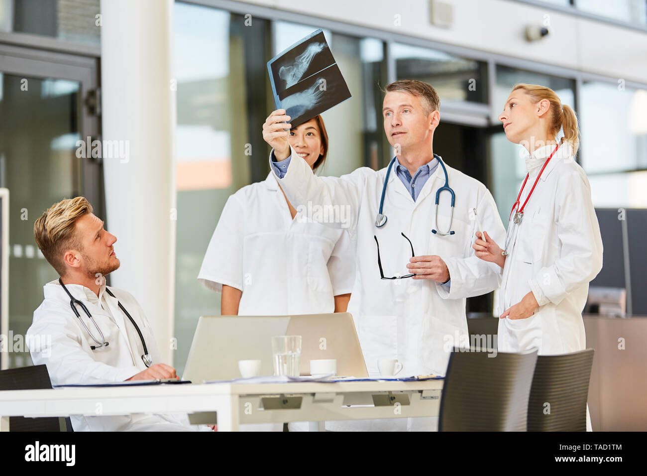 Lecturer or senior physician analyzes an X-ray together with his radiology team Stock Photo