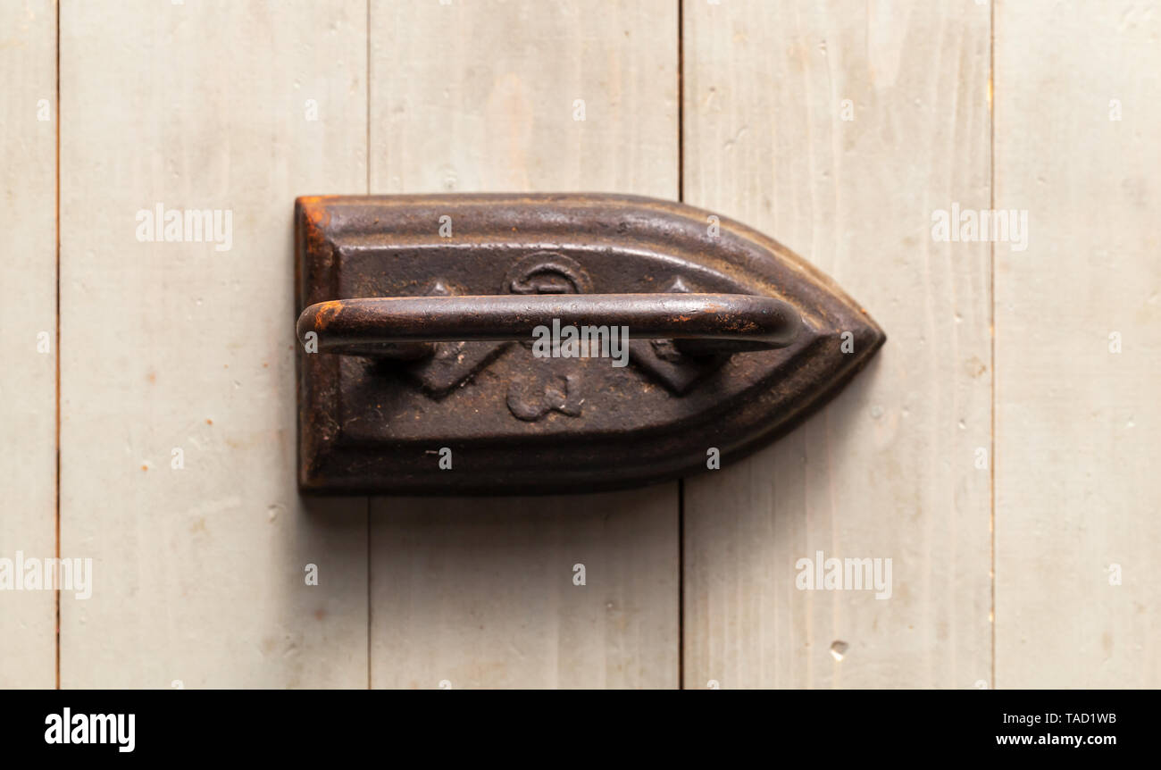 Old rusty iron stands on a gray wooden table, top view. Close-up photo with selective focus Stock Photo