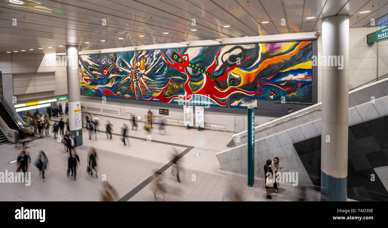 The Myth of Tomorrow: Taro Okamoto's Mural In Shibuya Station with blurred people walking around. Tokyo, Japan. Allegory of the atomic bombing Stock Photo