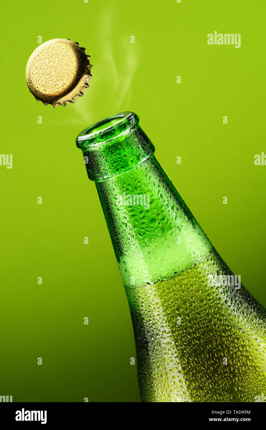 Bottle of beer with opening lid on a green background Stock Photo