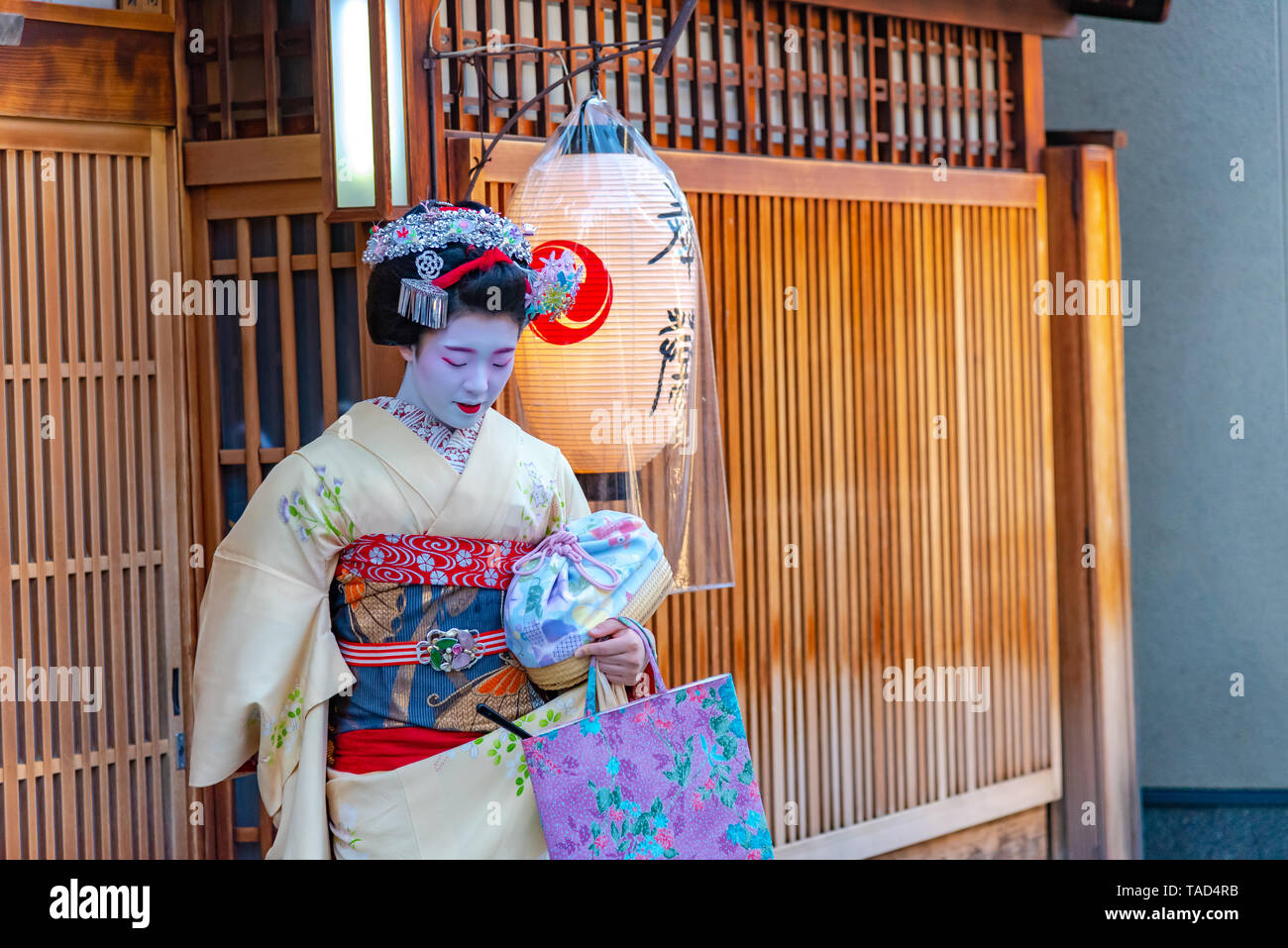 Geisha wearing traditional dress (kimono) leaving a tea house. Geisha are traditional female Japanese entertainers. Stock Photo
