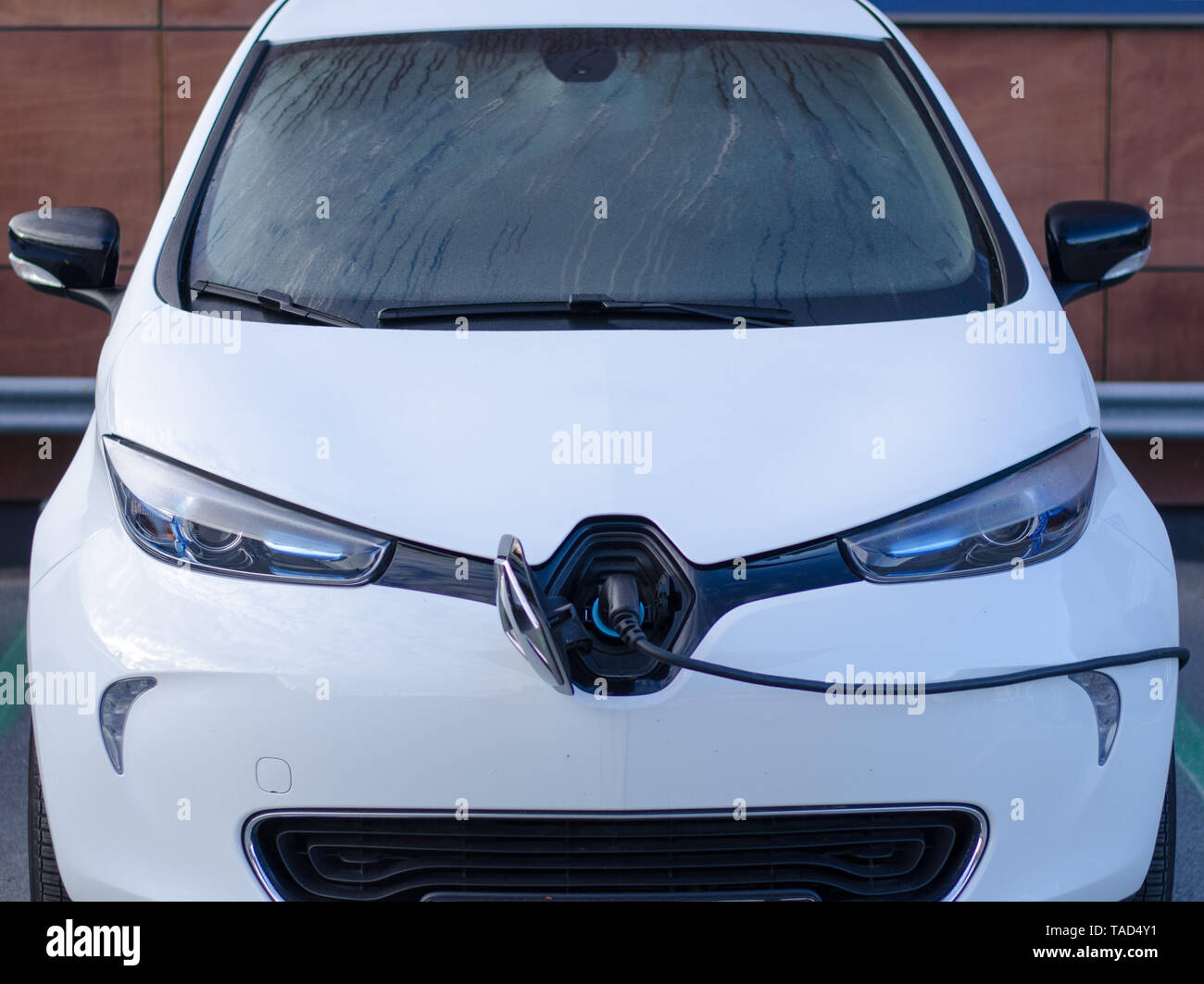 Stockholm, Sweden - 14 May 2019. The electric car, Renault Zoe in a parking lot recharging it's battery on a wet day. Stock Photo