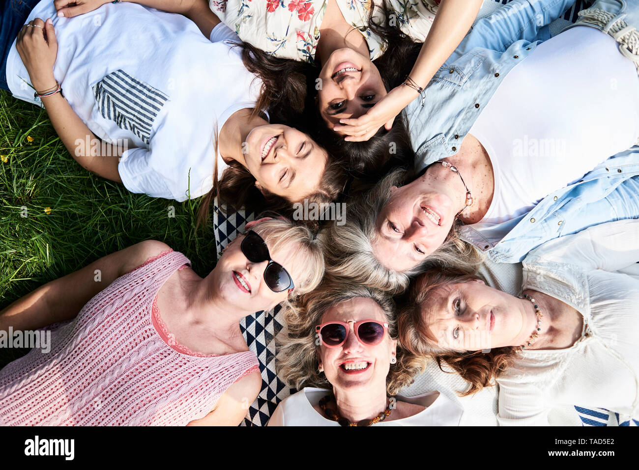 Top view of happy group of women lying in a meadow Stock Photo