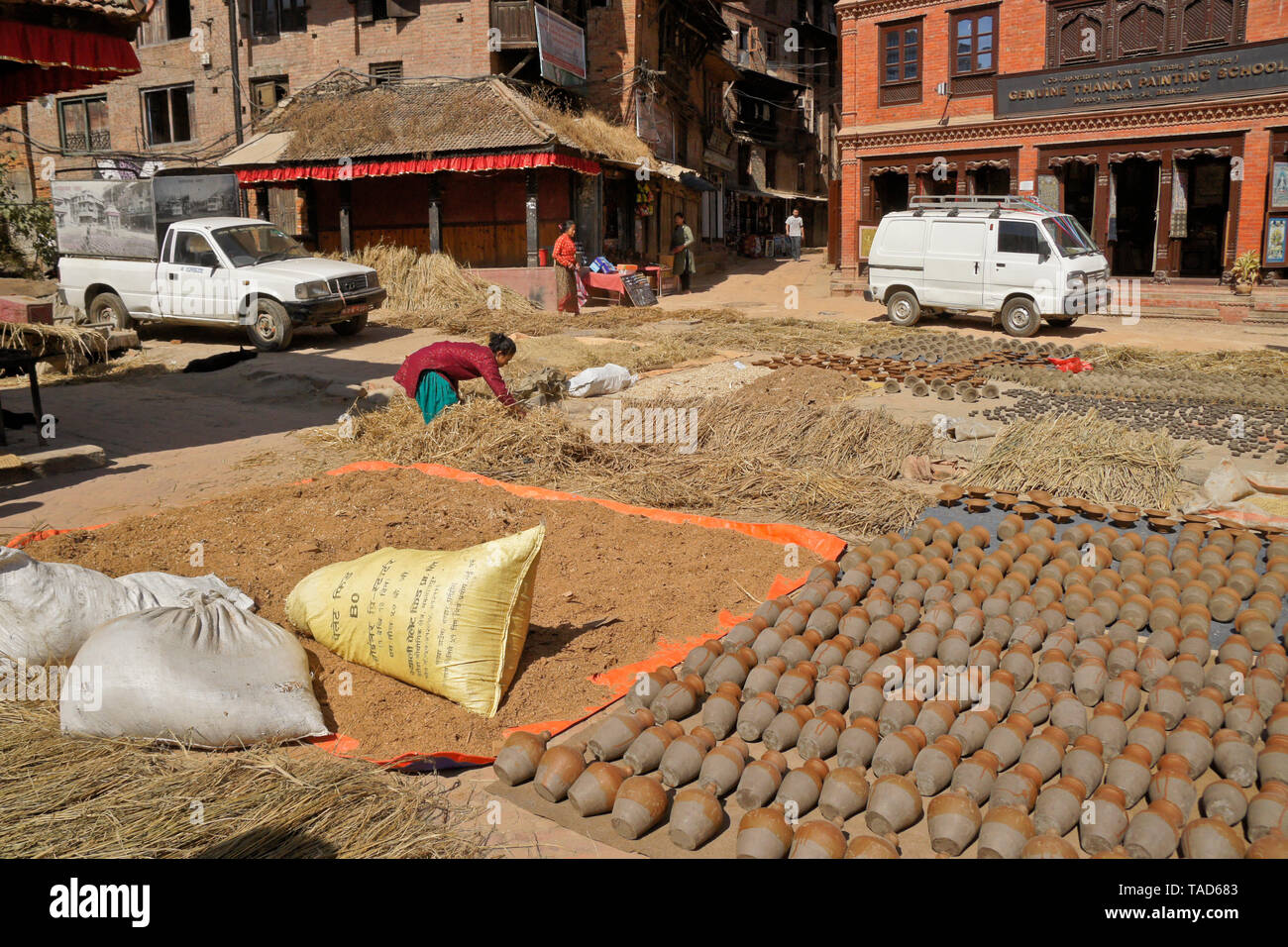 Clay pottery and harvested crops drying in sun in Kumale Tol (Potters' Square, Pottery Square), Bhaktapur, Kathmandu Valley, Nepal Stock Photo