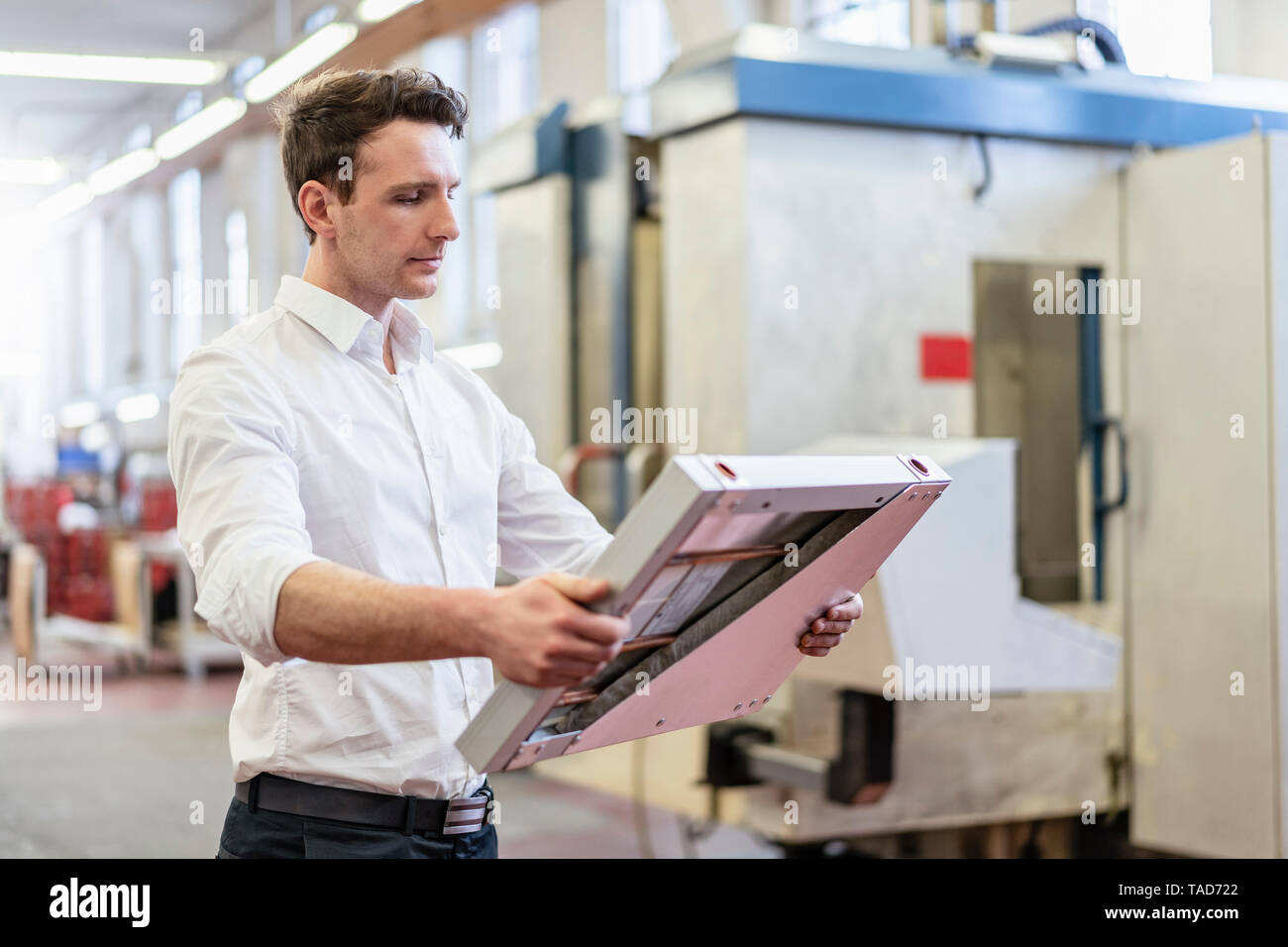 Man in factory holding solar cell Stock Photo