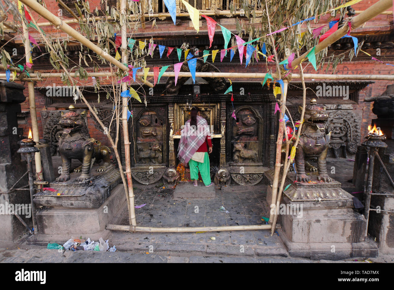 Woman worshipping in small Hindu shrine at base of Bhairabnath Mandir, Taumadhi Tol, Bhakatapur, Kathmandu Valley, Nepal Stock Photo