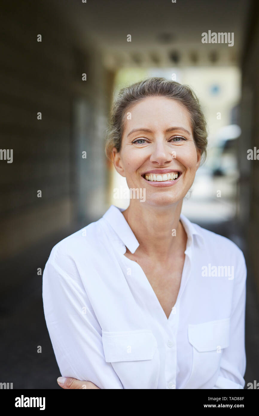 Portrait of happy woman wearing white shirt in the city Stock Photo Alamy