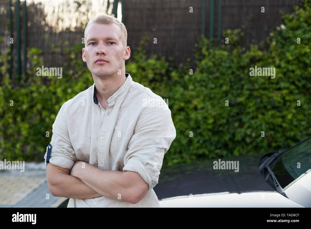 Portrait of young man standing beside car Stock Photo