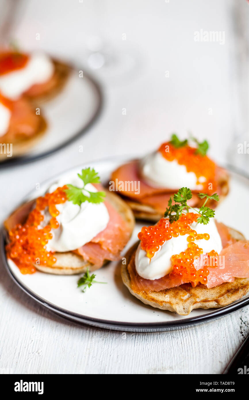 Russian style blini with salmon, sour cream and trout roe Stock Photo