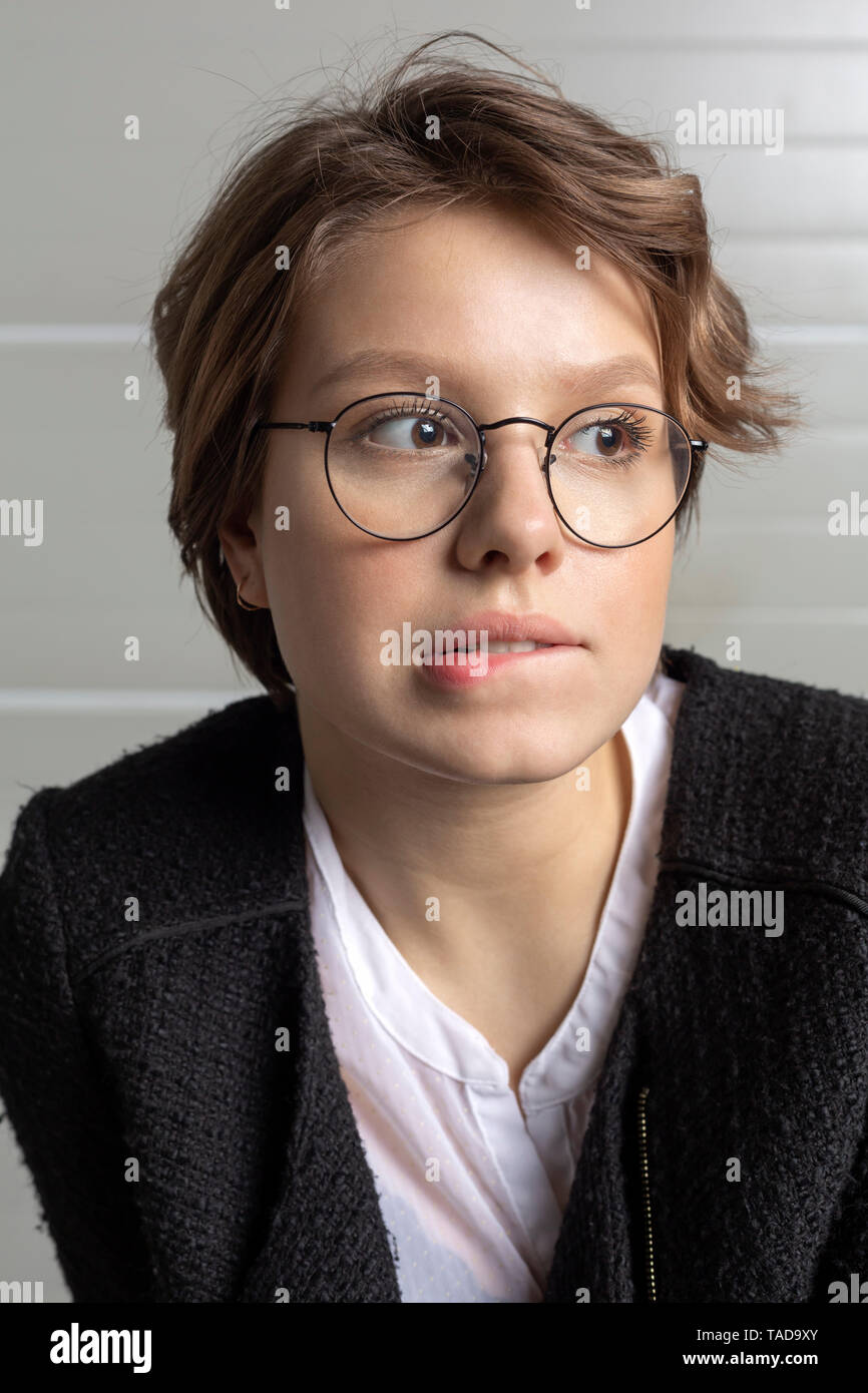 Portrait of young woman biting lip Stock Photo