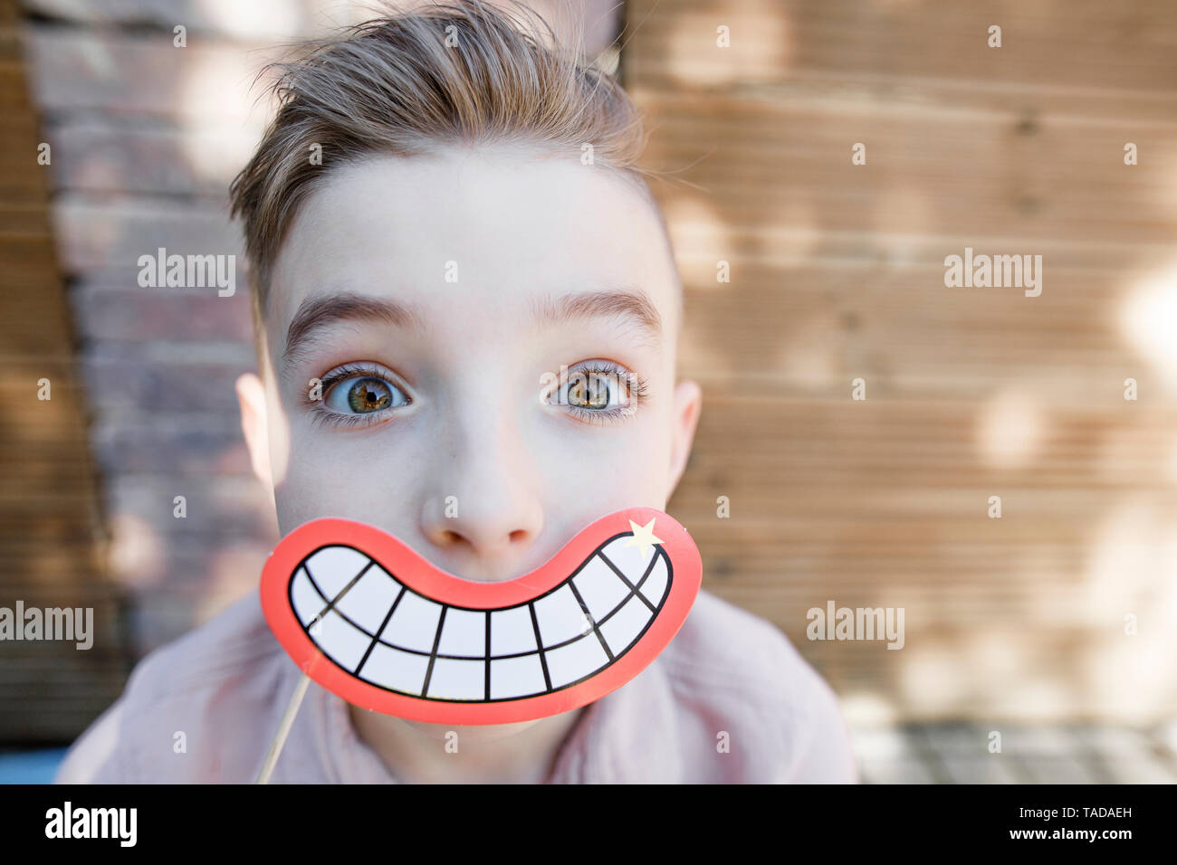 Blond boy with grinning mouth mask Stock Photo