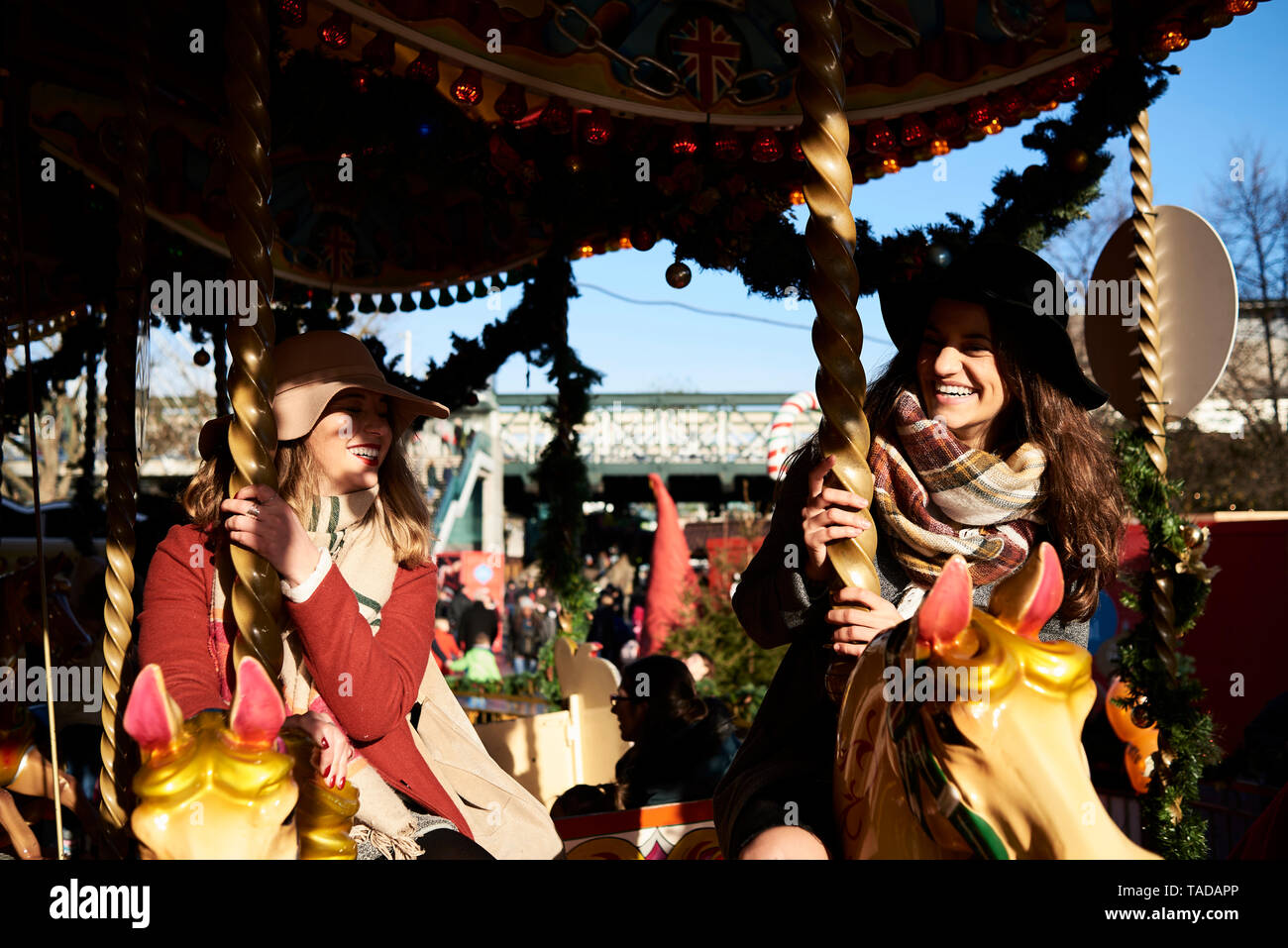 Two happy women having fun on a carousel Stock Photo