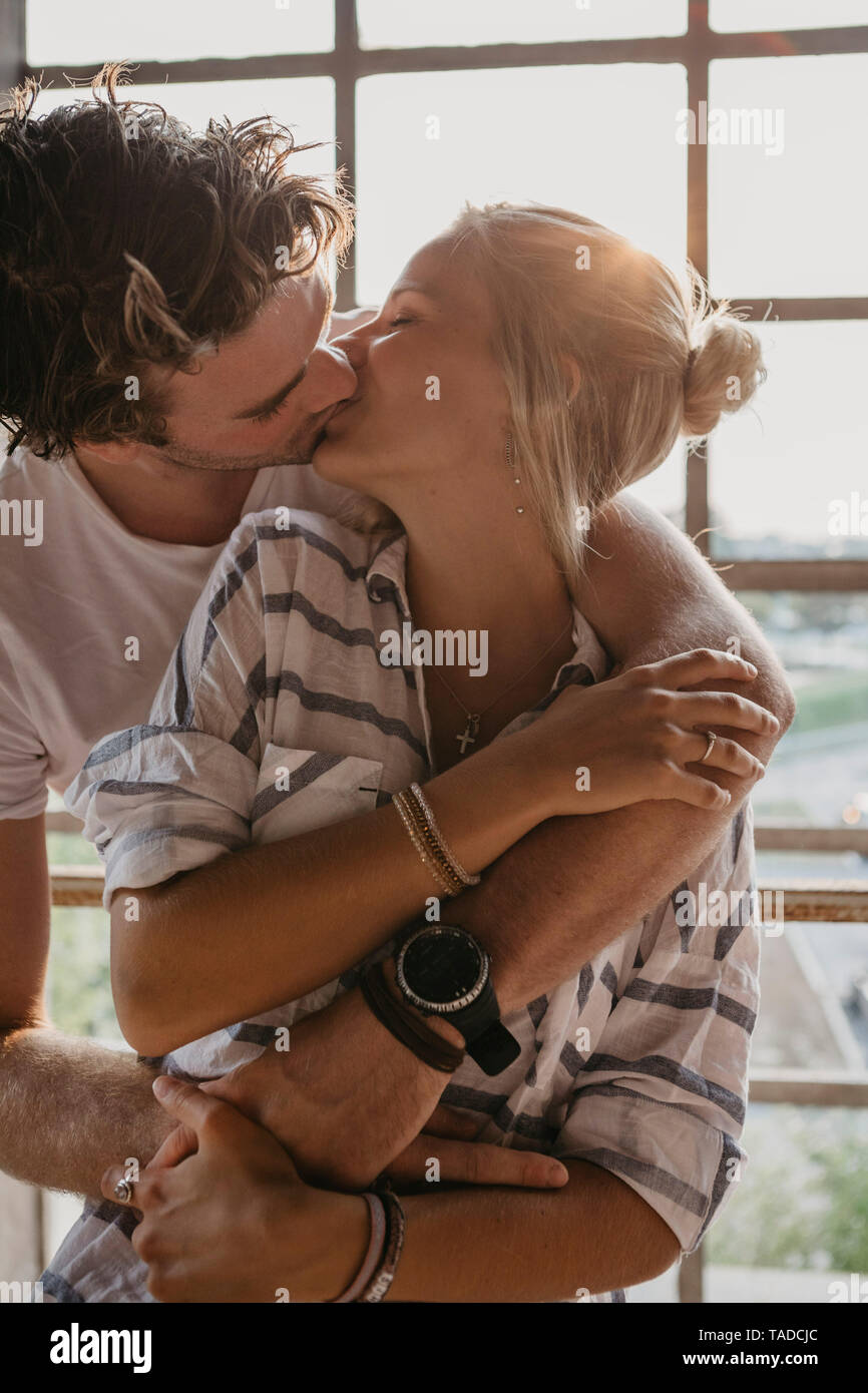 Young couple kissing at the window Stock Photo
