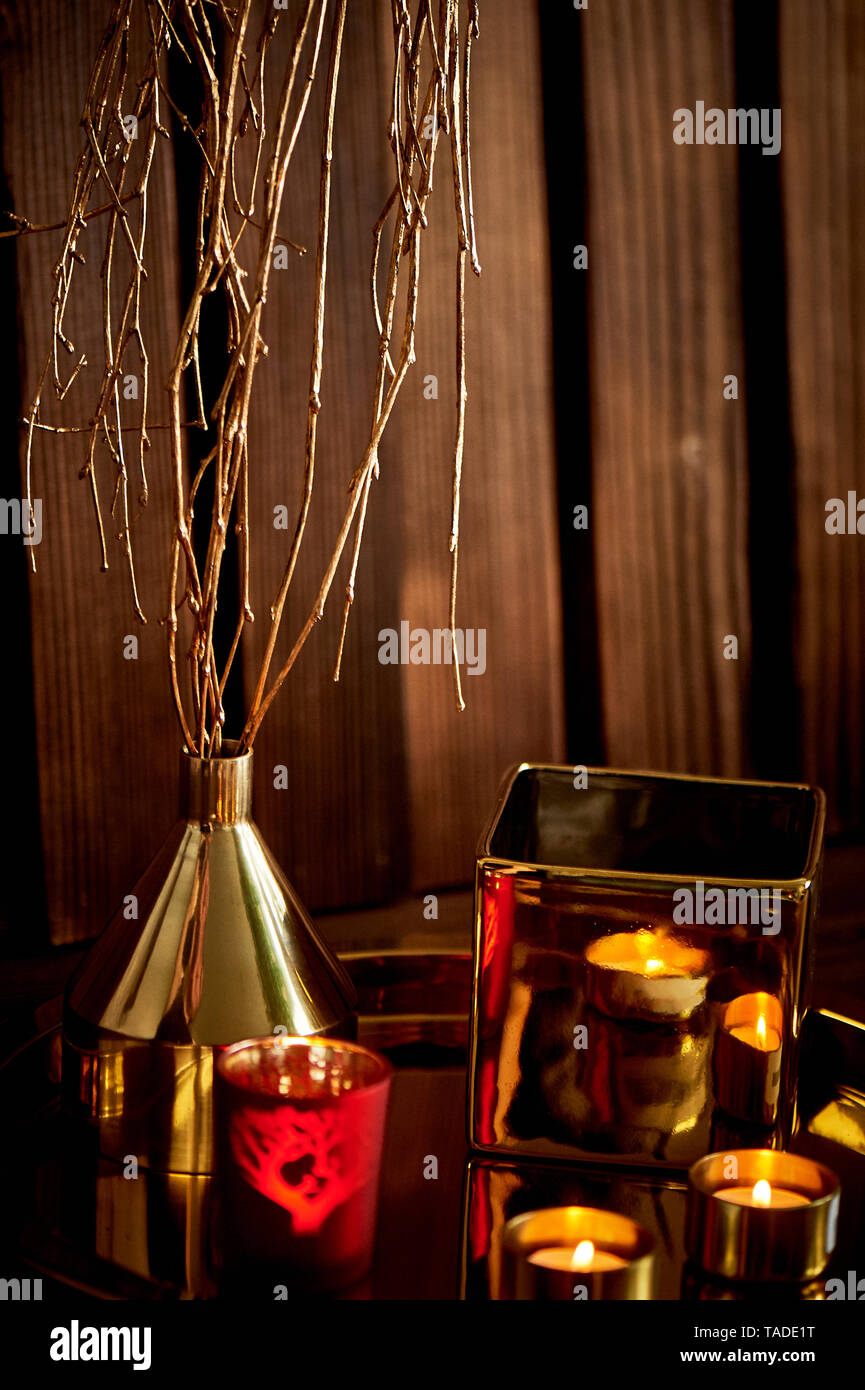Cozy decor.Gold and red. Burning candles, Golden vessels Stock Photo