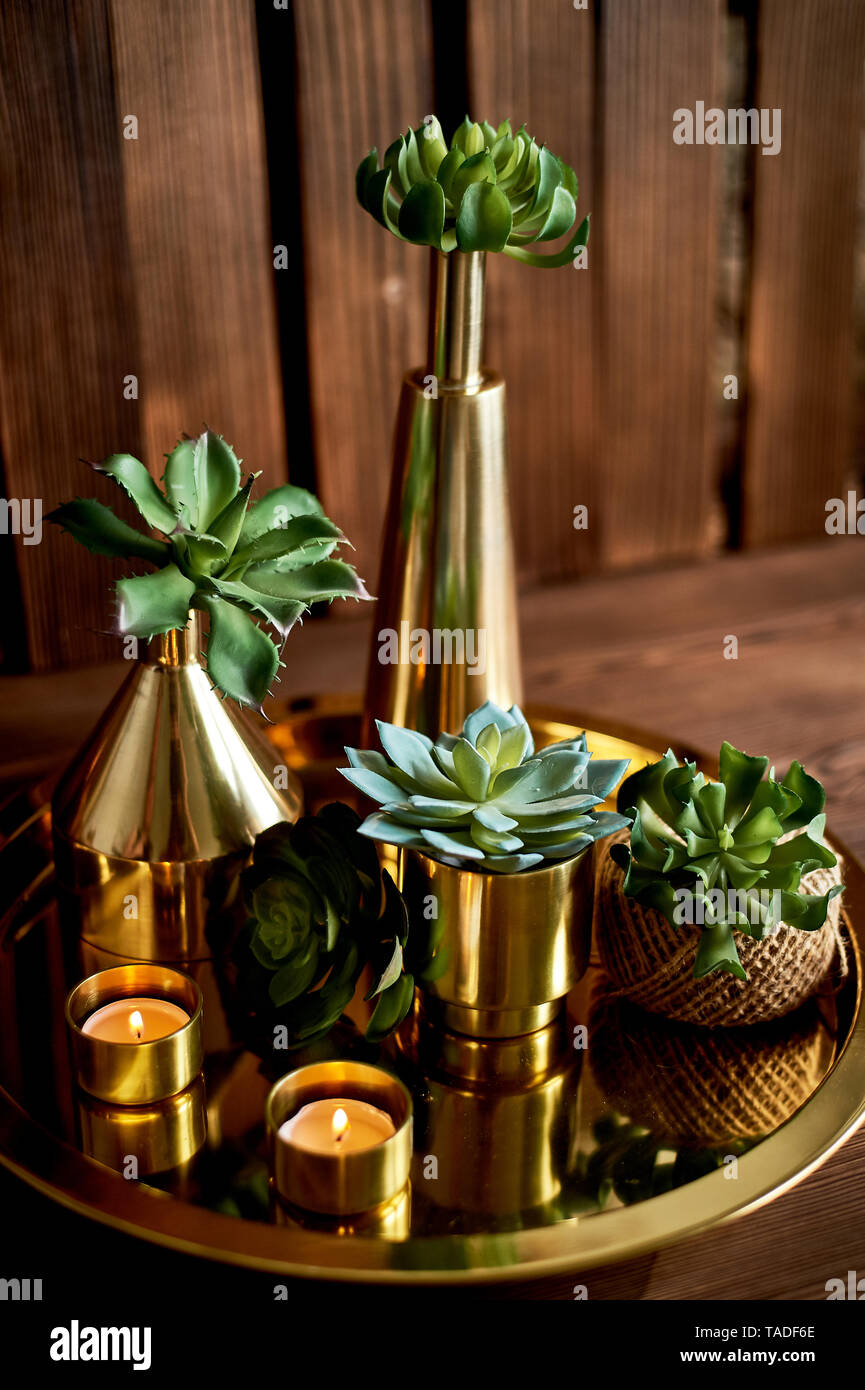 Cozy decor.Gold , burning candles, Golden vessels, succulents Stock