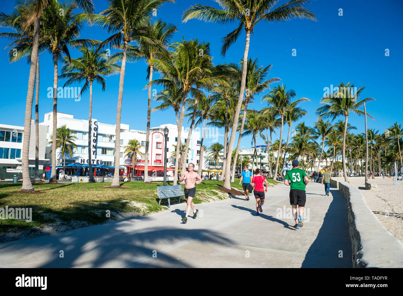 MIAMI - DECEMBER 27, 2017: Morning joggers and pedestrians share the beachfront boardwalk promenade at Lummus Park in South Beach. Stock Photo