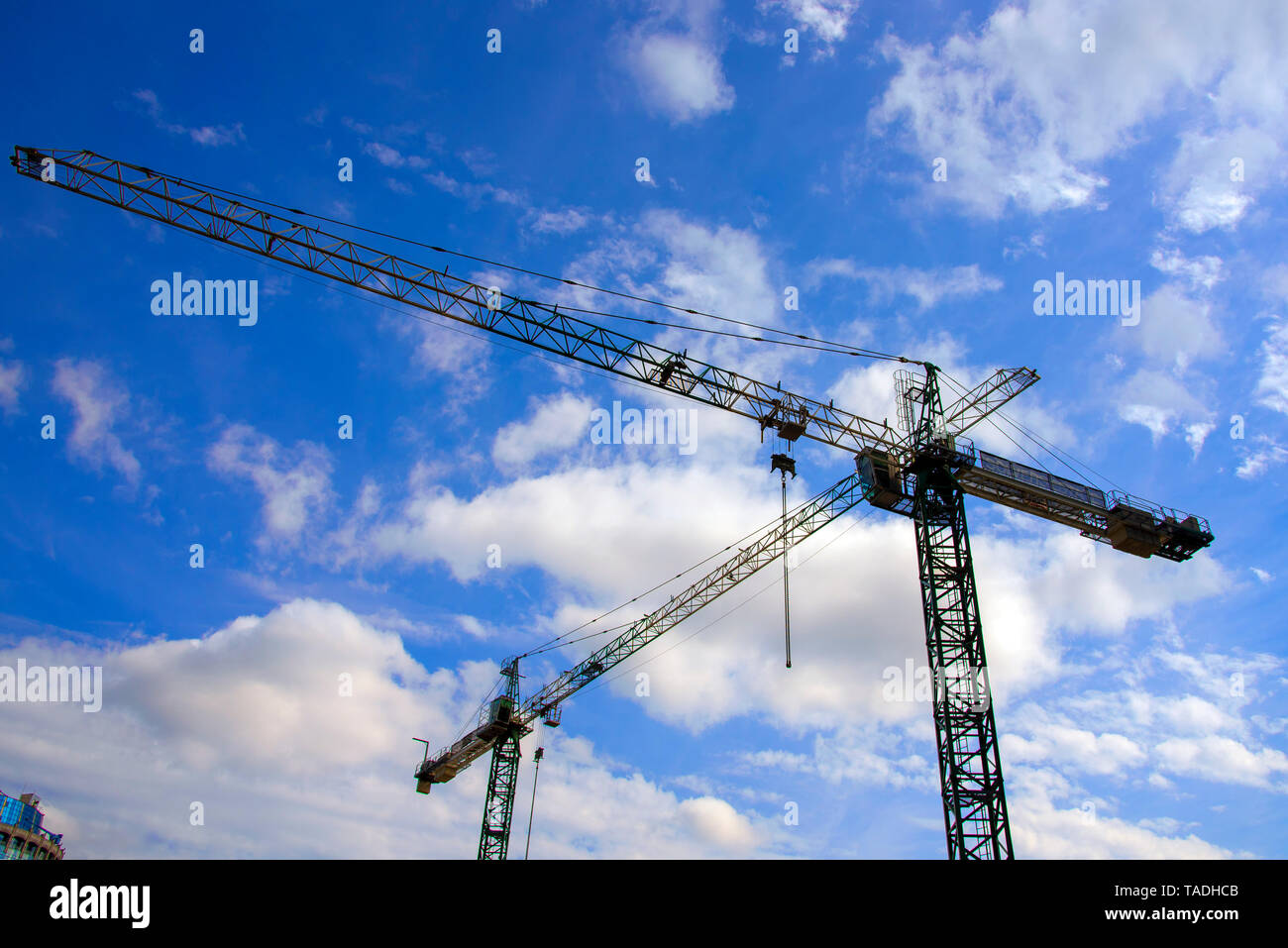 Silhouettes of cranes against the blue sky and clouds Stock Photo - Alamy