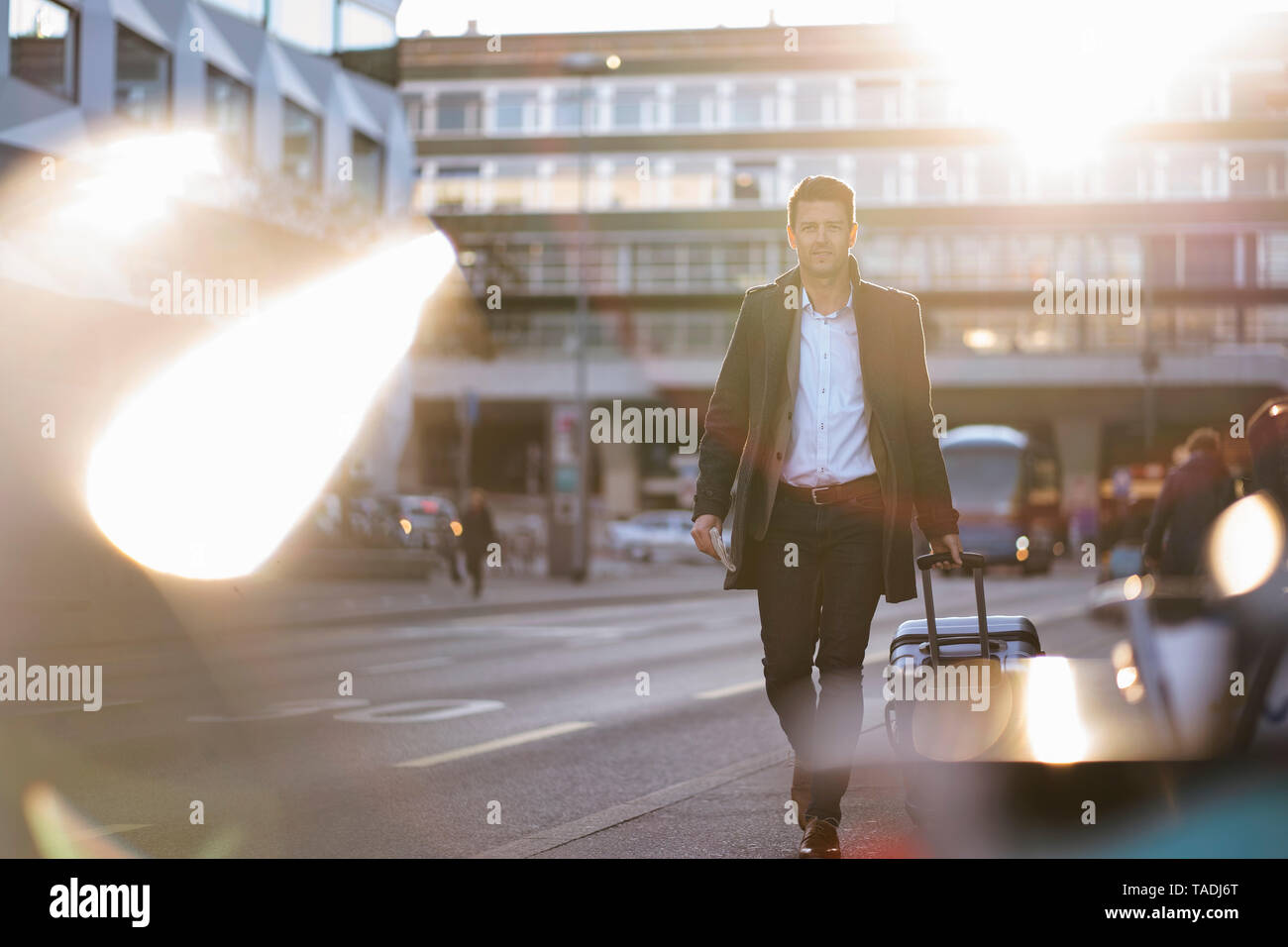 Businessman with suitcase on the move in the city Stock Photo