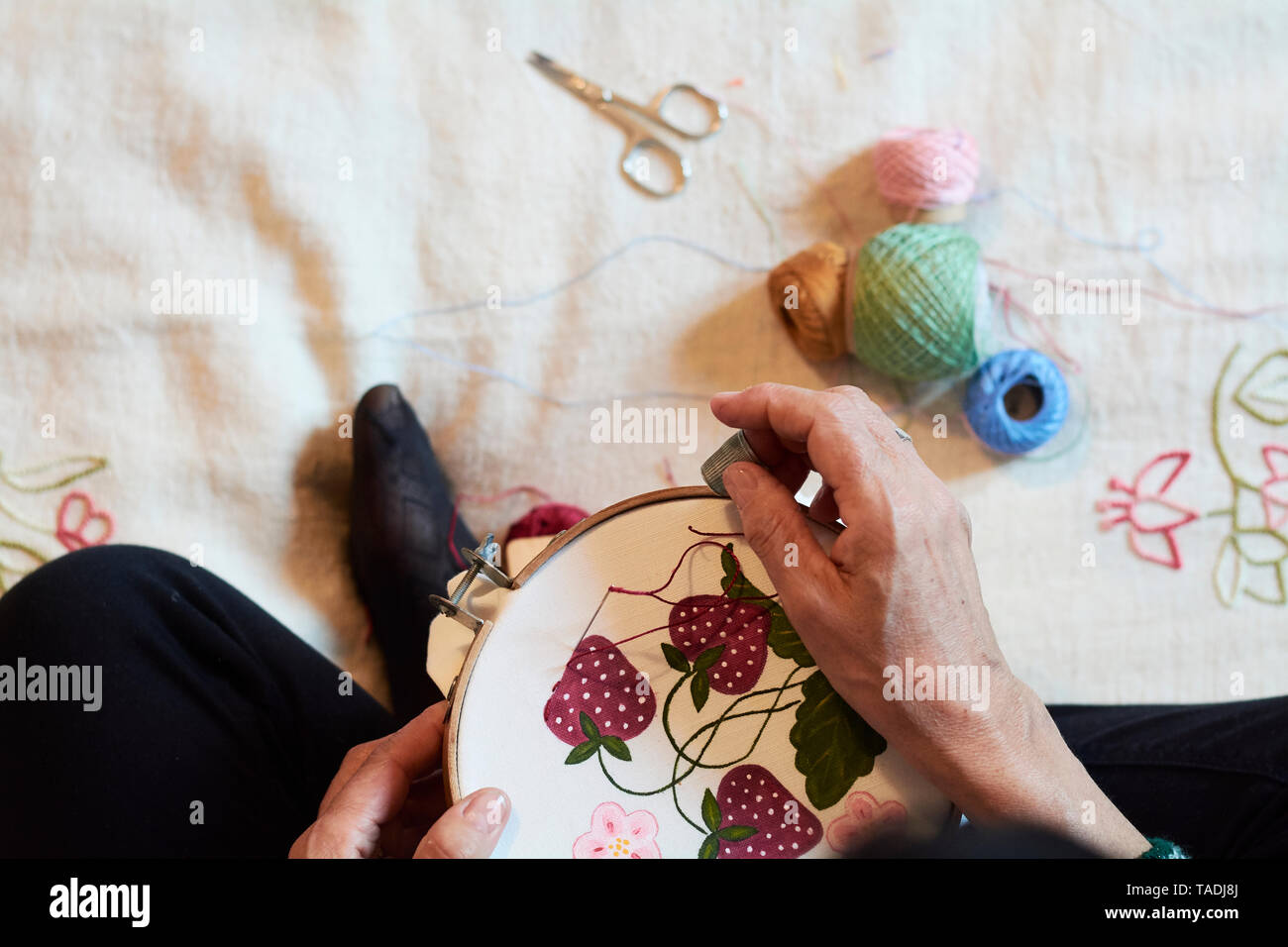 Close-up of woman embroidering strawberry pattern Stock Photo