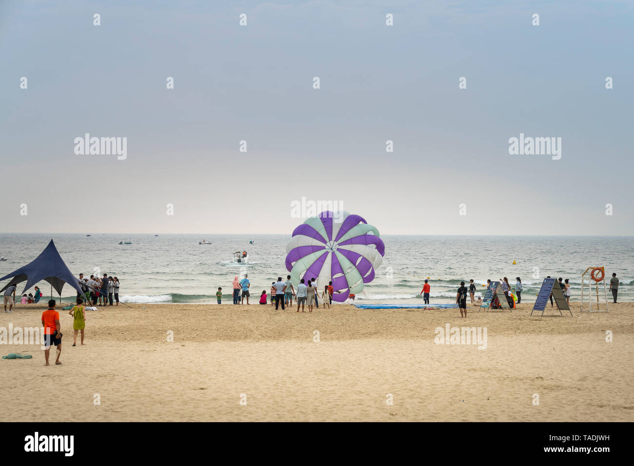 My Khe beach, Da Nang city, Vietnam - April 28, 2019: Parasailing at My Khe beach in Da Nang city. Popular entertainment for holiday travelers Stock Photo