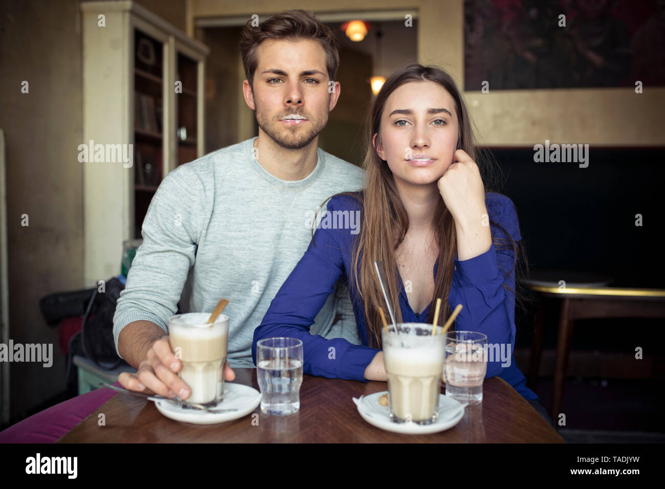 Portrait of young couple in a cafe with milk froth on lips Stock Photo