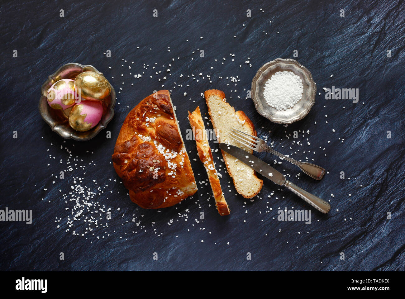 Easter plait, coarse sugar and Easter eggs, from above Stock Photo