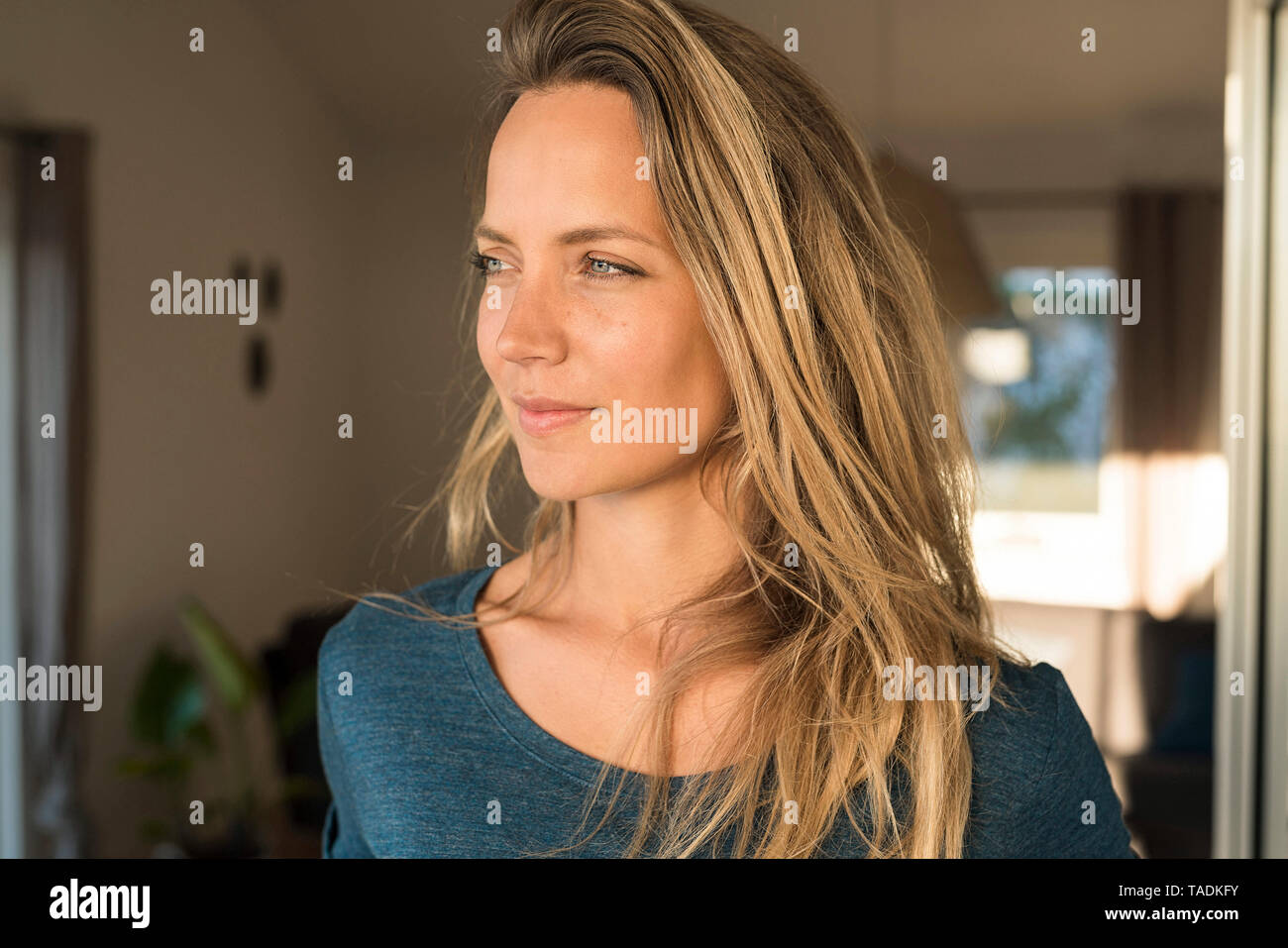Portrait of blond woman at home looking sideways Stock Photo