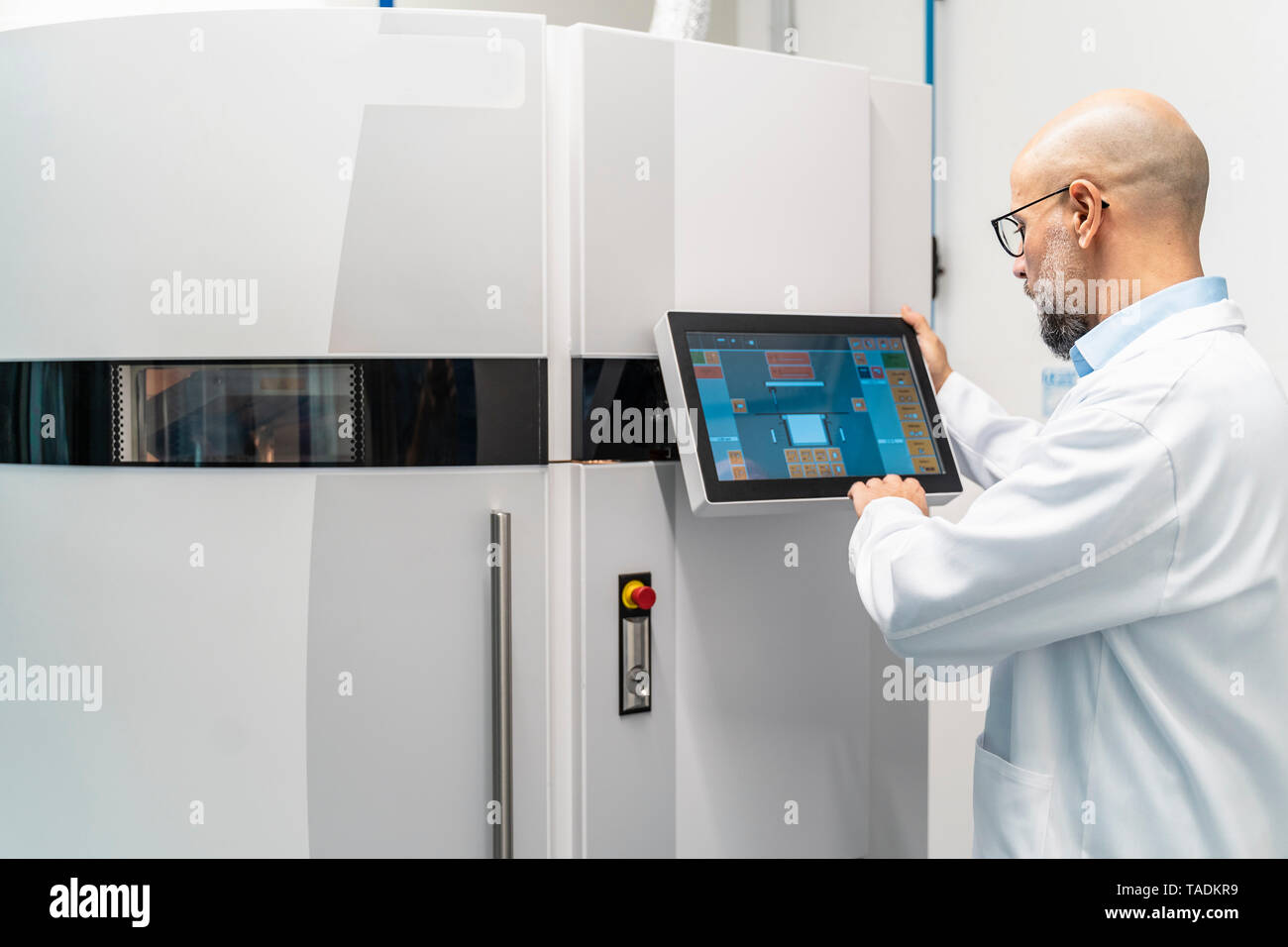 Technician wearing lab coat operating 3d printer Stock Photo