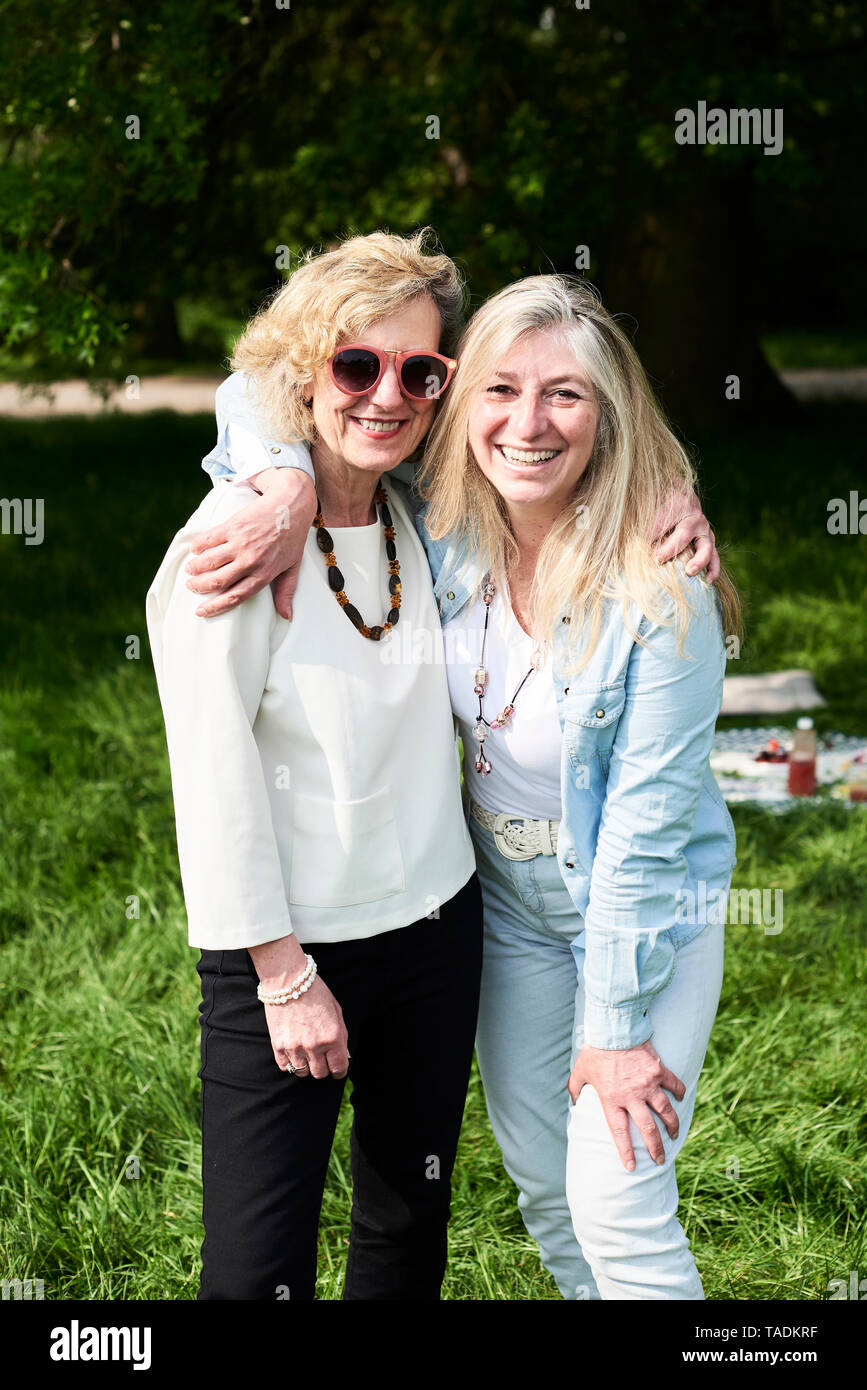 Portrait of two happy women embracing in park Stock Photo